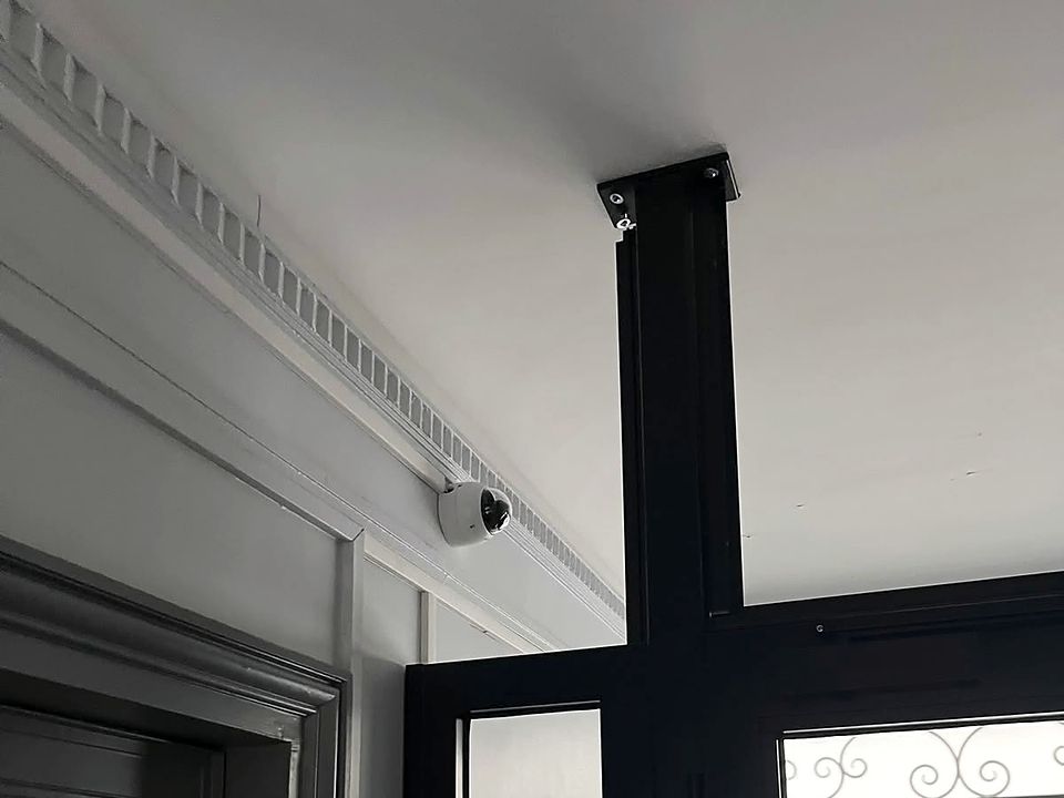 Caméra dôme sous la corniche d'un hall d'immeuble